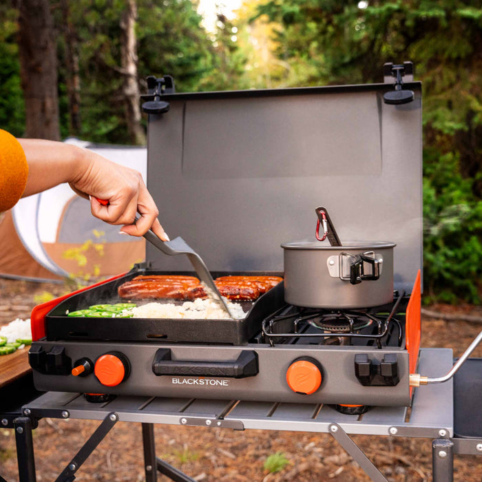 Blackstone 12x14" Camping Griddle and Side Burner For Outdoor Adventures

Pack your Griddle in the car and enjoy delicious meals wherever you end up. Built with a protective hood, latches, a handle, and a stow-and-go rear grease cup, this griddle packs up like a briefcase that is easy to carry with you. A 280 sq. in. Griddle and side burner with 14,400 combined BTUs make it easy to cook up your favorite griddle foods with the added versatility of being able to heat water, sauce or soups