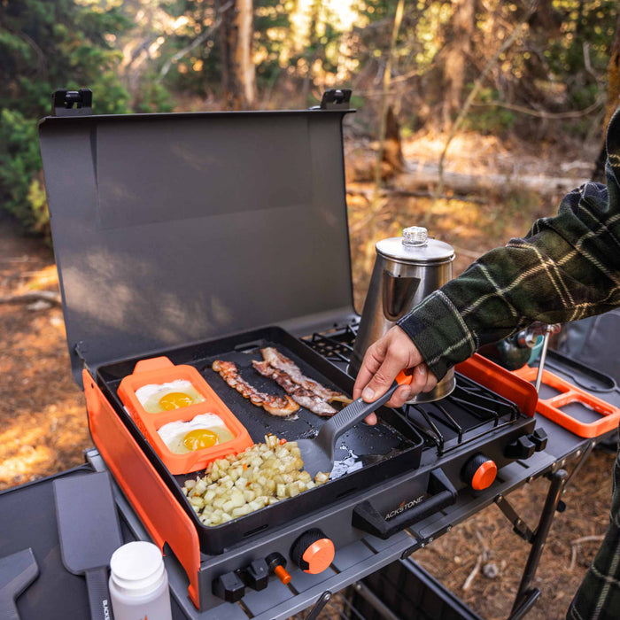 Blackstone 12x14" Camping Griddle and Side Burner For Outdoor Adventures

Pack your Griddle in the car and enjoy delicious meals wherever you end up. Built with a protective hood, latches, a handle, and a stow-and-go rear grease cup, this griddle packs up like a briefcase that is easy to carry with you. A 280 sq. in. Griddle and side burner with 14,400 combined BTUs make it easy to cook up your favorite griddle foods with the added versatility of being able to heat water, sauce or soups