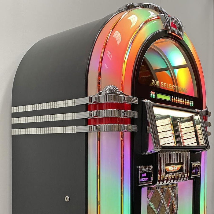 Experience the authentic American craftsmanship of the Rock-Ola Hand Built Bubbler Vinyl 45 in Gloss Black (RB8E-GB). This iconic jukebox plays 100 vinyl records, offers Bluetooth streaming, and combines the timeless design of the Wurlitzer 1015 with mesmerizing bubble tubes. Enjoy superior sound and enchanting visuals in this robust hand-built masterpiece.